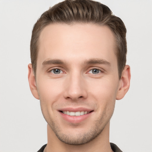 Joyful white young-adult male with short  brown hair and grey eyes