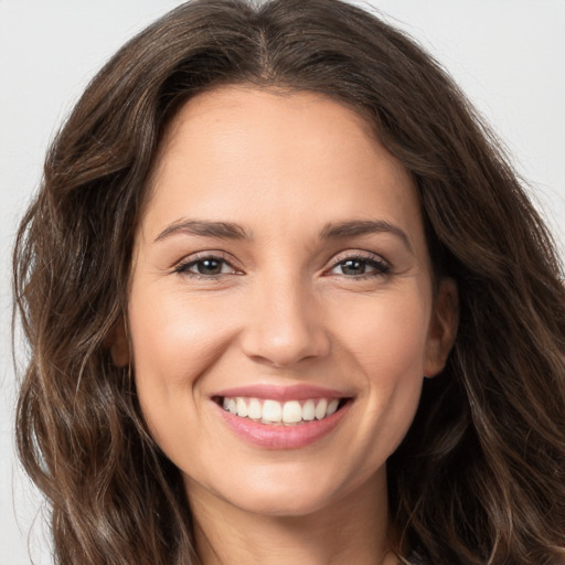 Joyful white young-adult female with long  brown hair and brown eyes