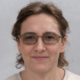 Joyful white adult female with medium  brown hair and grey eyes