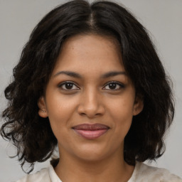 Joyful black young-adult female with medium  brown hair and brown eyes