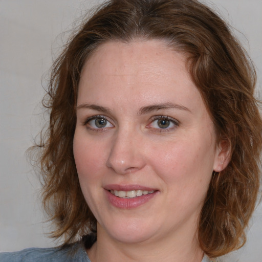 Joyful white adult female with medium  brown hair and blue eyes