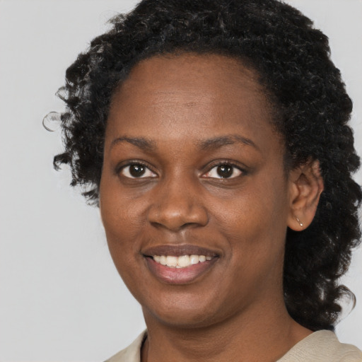 Joyful black young-adult female with short  black hair and brown eyes
