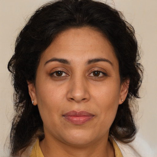 Joyful latino adult female with medium  brown hair and brown eyes