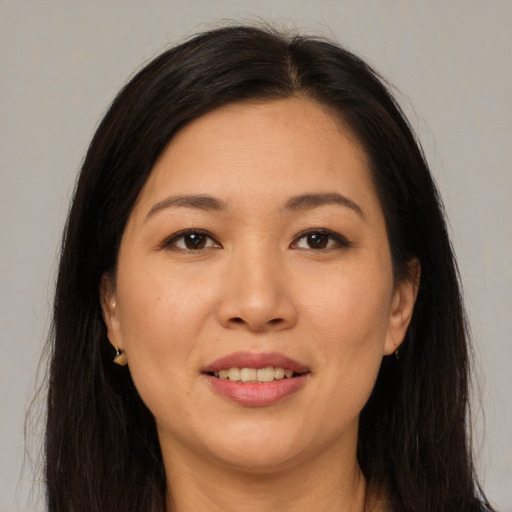 Joyful asian young-adult female with long  brown hair and brown eyes