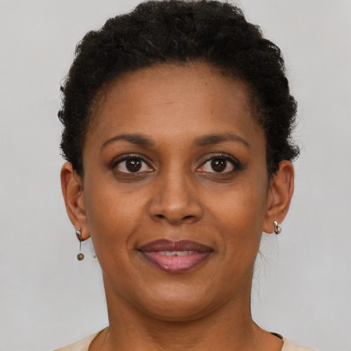 Joyful black young-adult female with short  brown hair and brown eyes