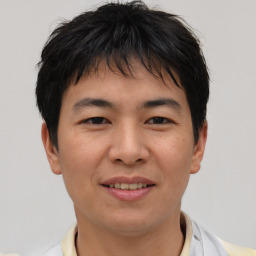 Joyful asian young-adult male with short  brown hair and brown eyes