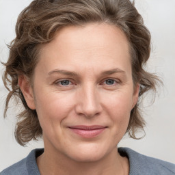 Joyful white adult female with medium  brown hair and blue eyes