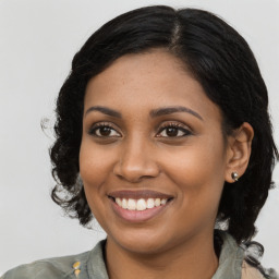 Joyful black young-adult female with long  brown hair and brown eyes