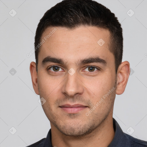 Joyful white young-adult male with short  brown hair and brown eyes