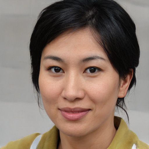 Joyful asian young-adult female with medium  brown hair and brown eyes