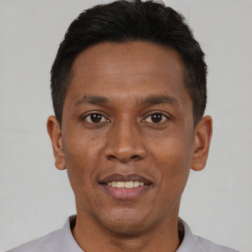 Joyful black adult male with short  black hair and brown eyes