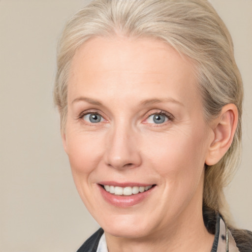 Joyful white adult female with medium  blond hair and blue eyes