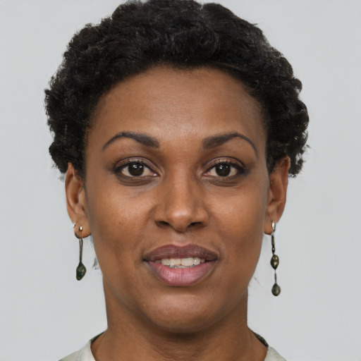 Joyful black adult female with short  brown hair and brown eyes