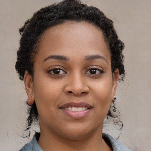 Joyful black young-adult female with medium  brown hair and brown eyes