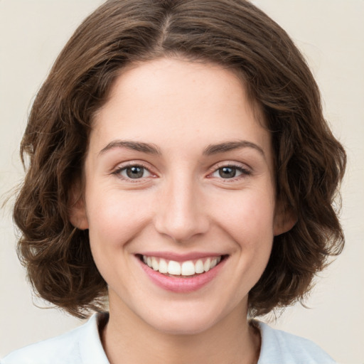 Joyful white young-adult female with medium  brown hair and green eyes