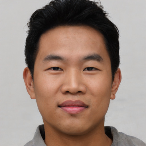 Joyful asian young-adult male with short  black hair and brown eyes