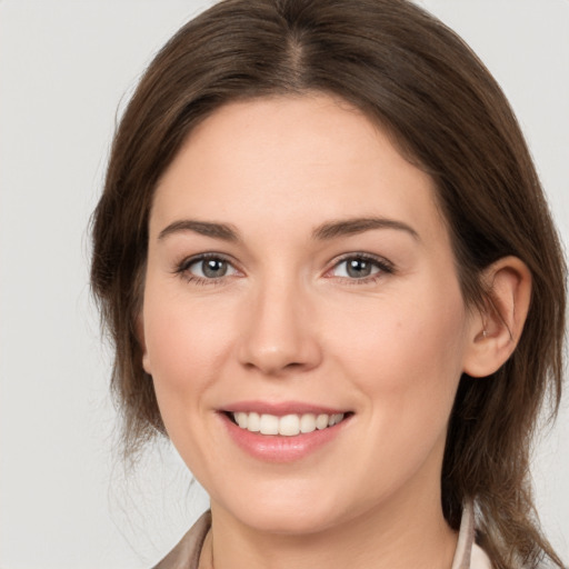 Joyful white young-adult female with medium  brown hair and grey eyes