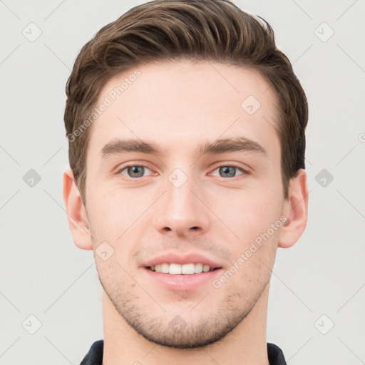 Joyful white young-adult male with short  brown hair and grey eyes