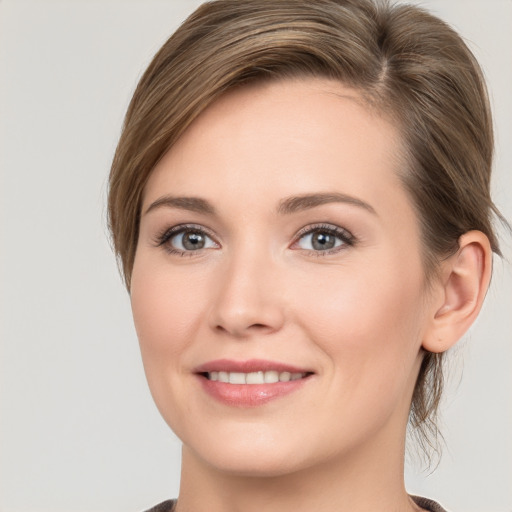 Joyful white young-adult female with medium  brown hair and grey eyes