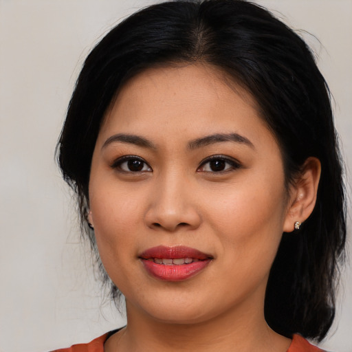 Joyful asian young-adult female with medium  brown hair and brown eyes