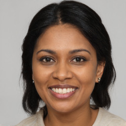 Joyful black adult female with medium  brown hair and brown eyes