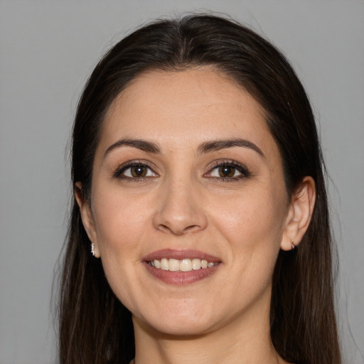 Joyful white young-adult female with long  brown hair and brown eyes