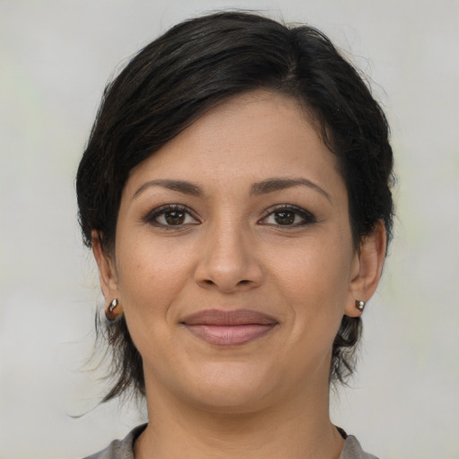 Joyful latino young-adult female with medium  brown hair and brown eyes