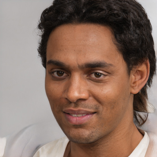 Joyful white young-adult male with short  black hair and brown eyes