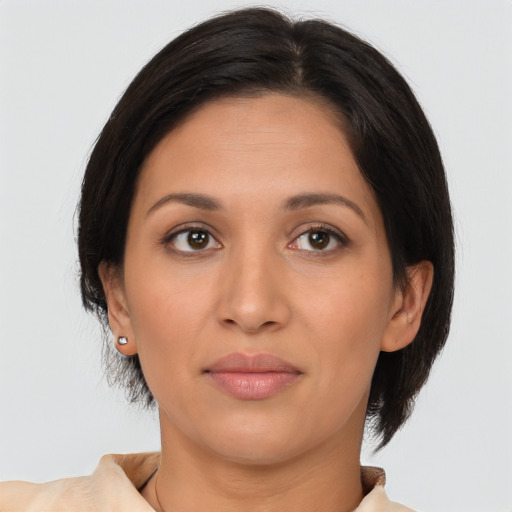 Joyful latino young-adult female with medium  brown hair and brown eyes