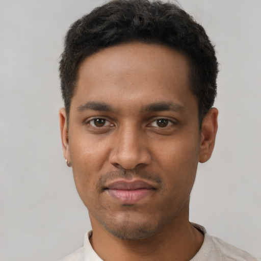 Joyful black young-adult male with short  black hair and brown eyes