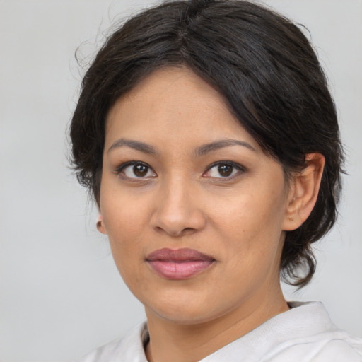 Joyful latino young-adult female with medium  brown hair and brown eyes