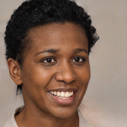 Joyful black young-adult female with short  black hair and brown eyes
