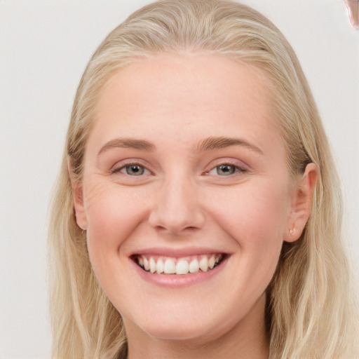 Joyful white young-adult female with long  blond hair and blue eyes