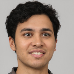 Joyful latino young-adult male with short  brown hair and brown eyes