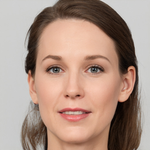 Joyful white young-adult female with medium  brown hair and grey eyes