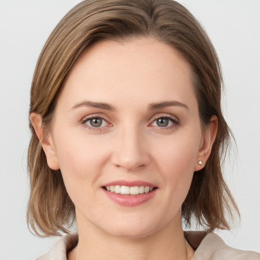 Joyful white young-adult female with medium  brown hair and grey eyes