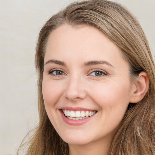 Joyful white young-adult female with long  brown hair and green eyes