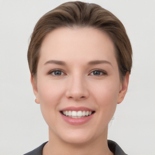 Joyful white young-adult female with short  brown hair and grey eyes