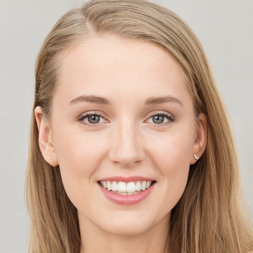 Joyful white young-adult female with long  brown hair and blue eyes