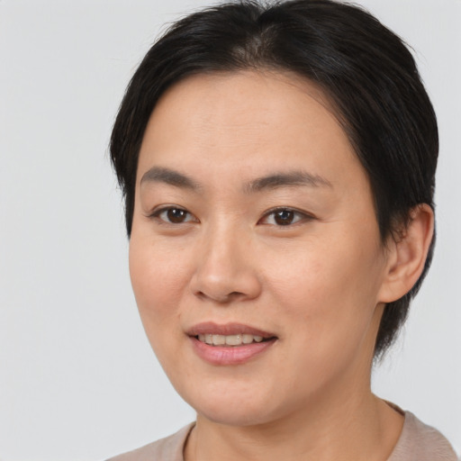 Joyful asian adult female with medium  brown hair and brown eyes