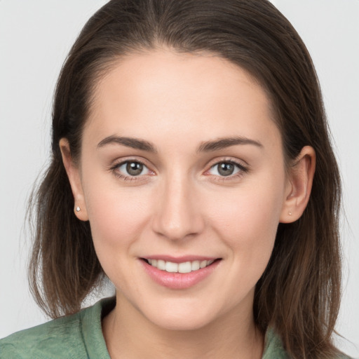 Joyful white young-adult female with long  brown hair and grey eyes