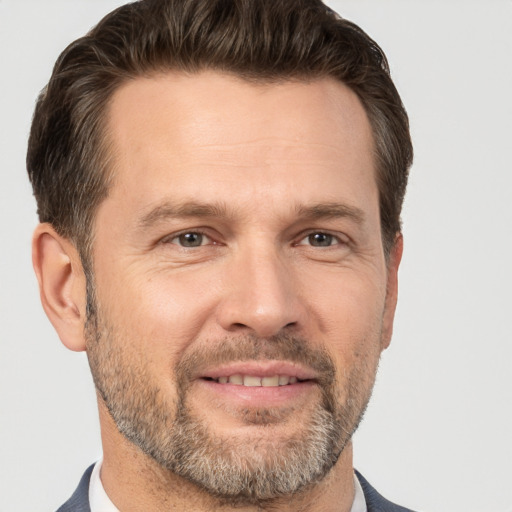 Joyful white adult male with short  brown hair and brown eyes