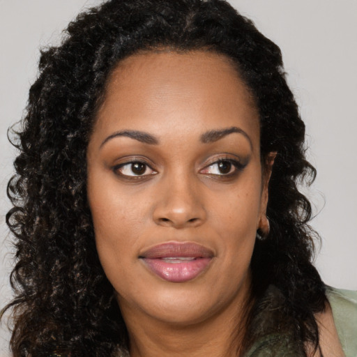Joyful black young-adult female with long  black hair and brown eyes