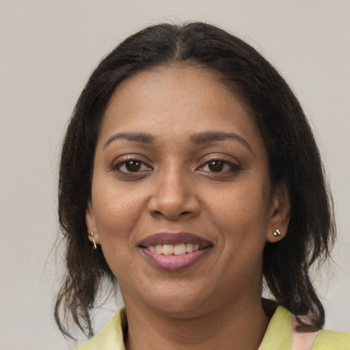 Joyful black young-adult female with medium  brown hair and brown eyes