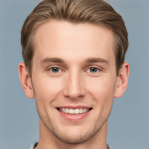 Joyful white young-adult male with short  brown hair and grey eyes