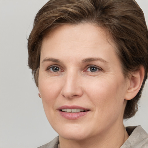 Joyful white adult female with medium  brown hair and grey eyes