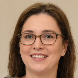 Joyful white adult female with medium  brown hair and green eyes