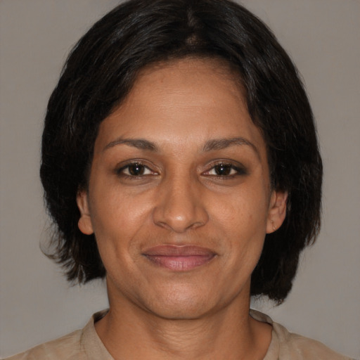 Joyful black adult female with medium  brown hair and brown eyes