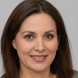 Joyful white adult female with long  brown hair and brown eyes