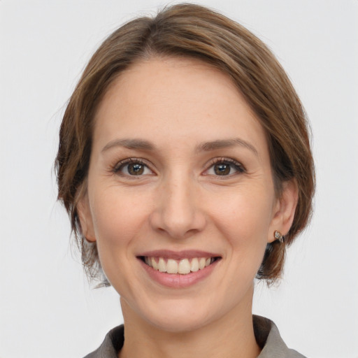 Joyful white young-adult female with medium  brown hair and grey eyes